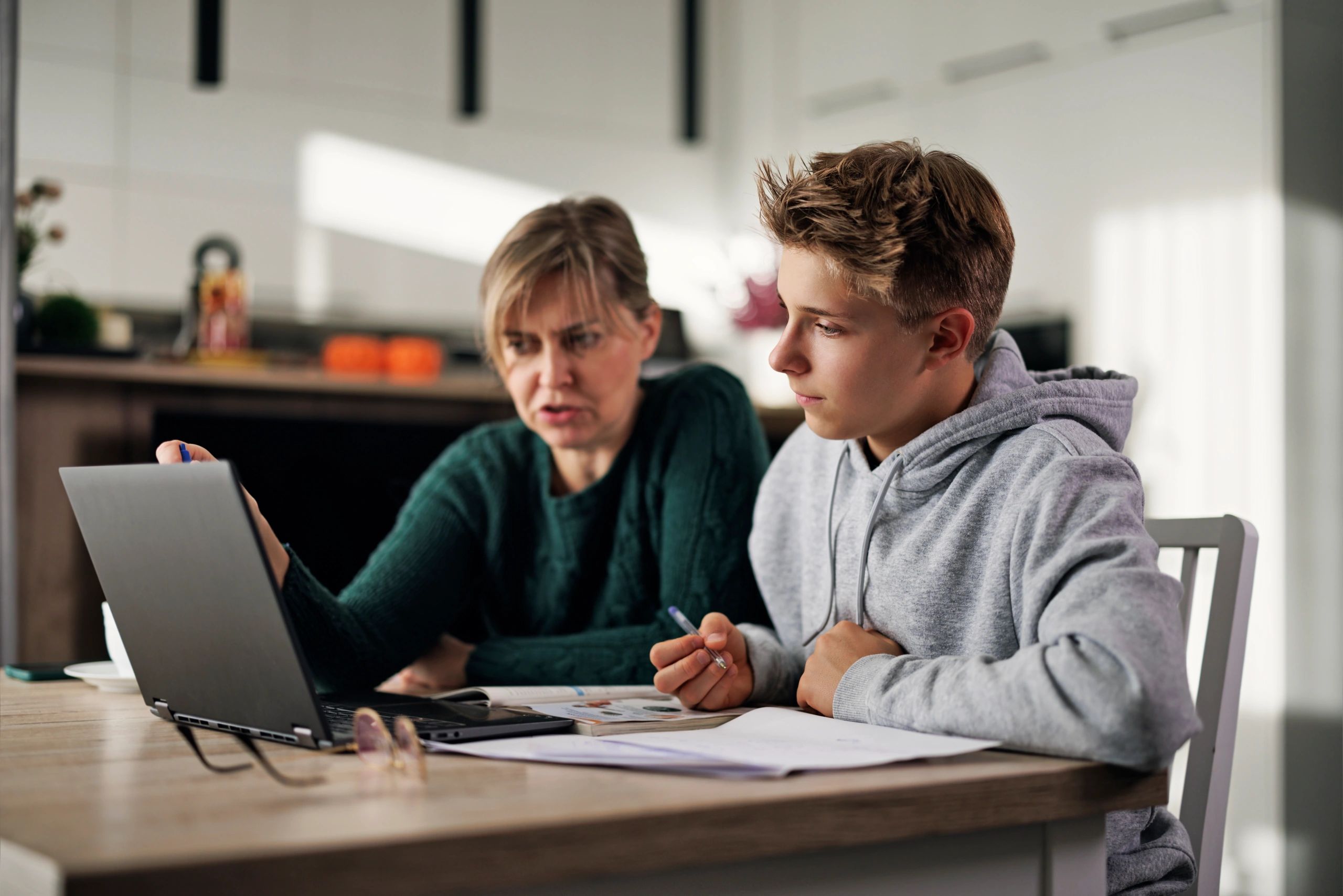 Mother helping her son with homework at home