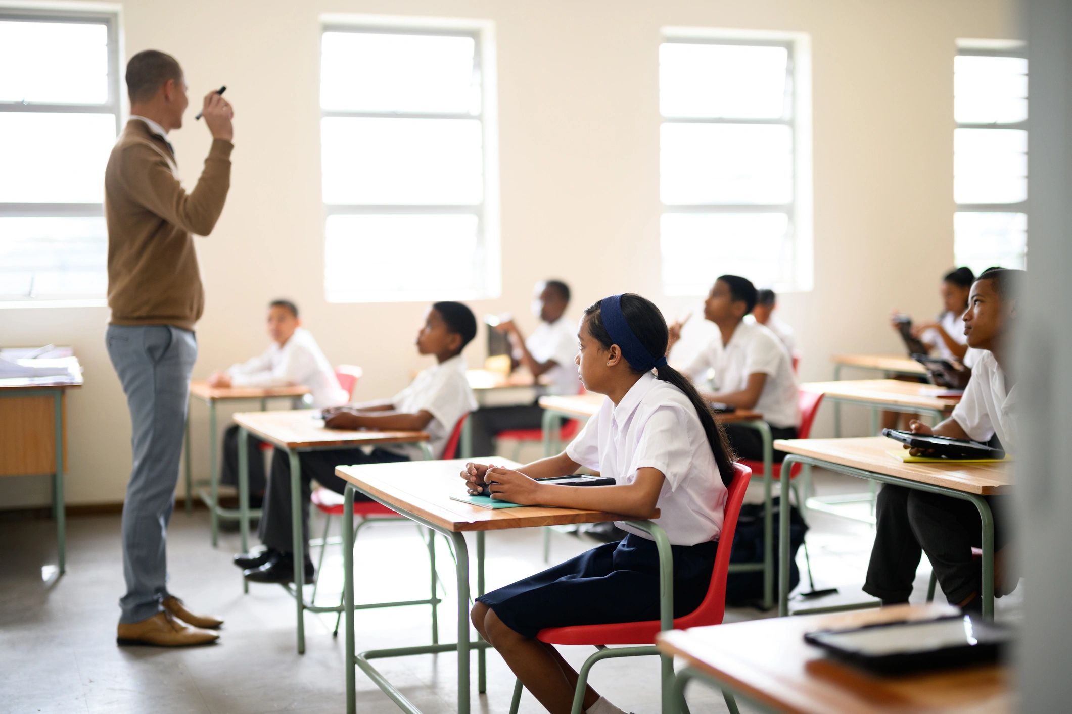 Schoolgirl in class listening to teacher